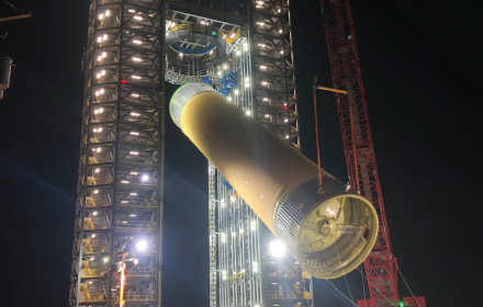 A rocket being assembled at night on a launch tower illuminated by artificial lights at NASA's Marshall Space Flight Center.
