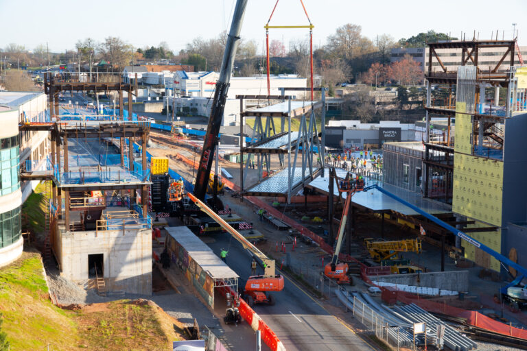 Construction site with cranes and heavy machinery during the 72-foot tall bridge development.