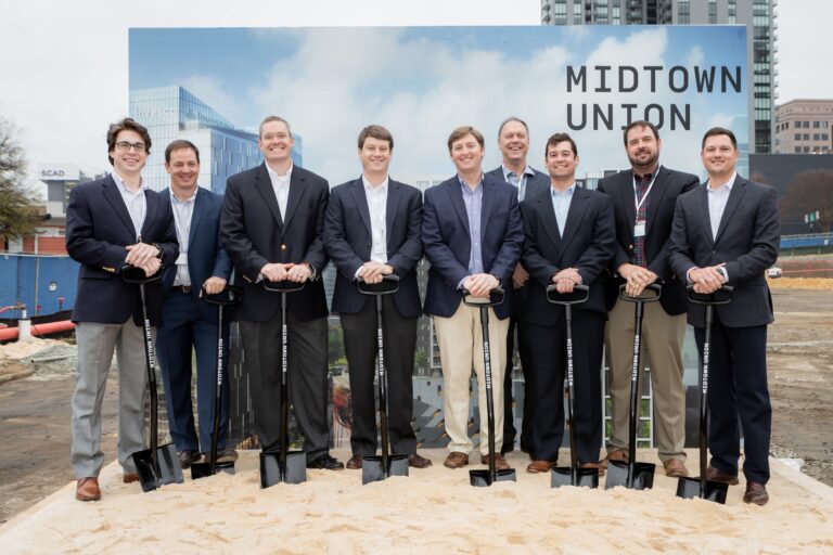 Group of men in business attire partaking in a groundbreaking ceremony.