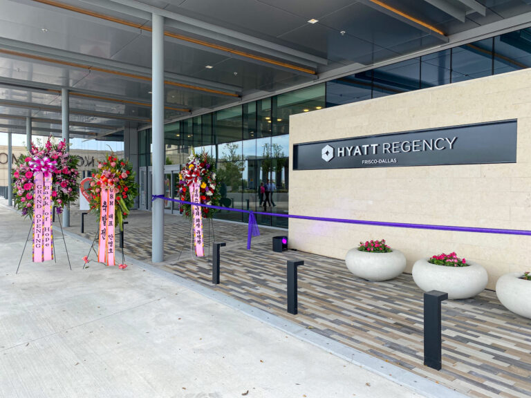 Entrance to the Hyatt Regency Frisco hotel adorned with floral arrangements and ribbons, completed by Brasfield & Gorrie.