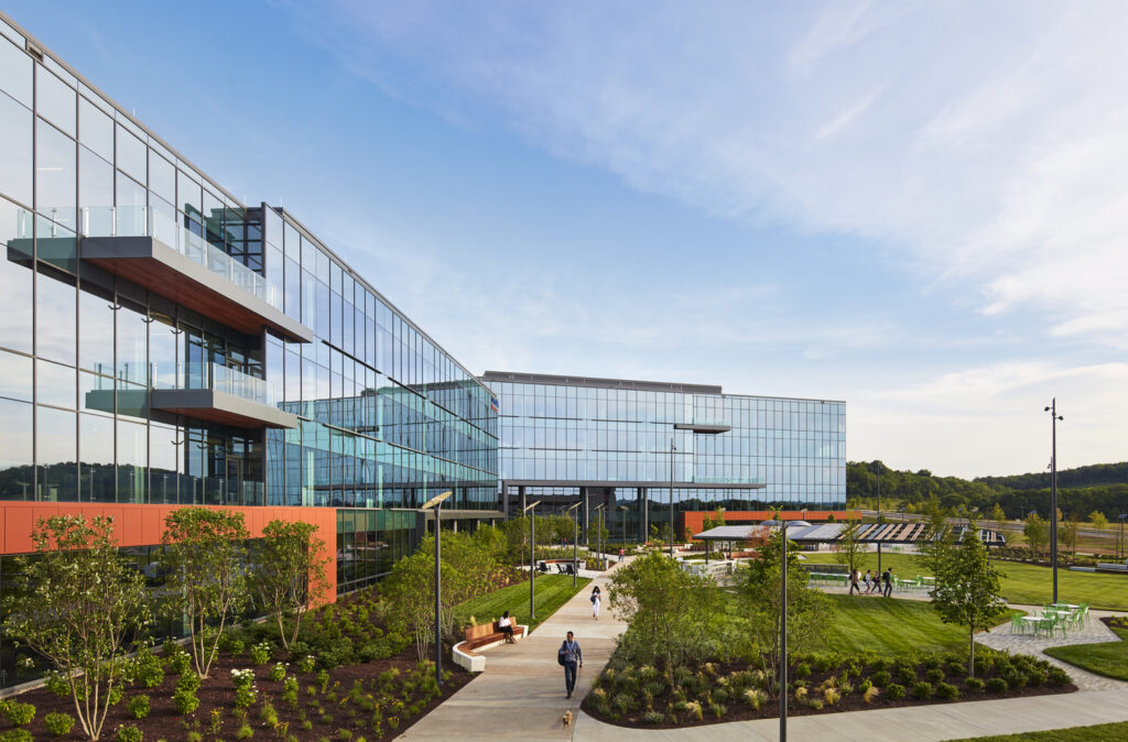 Modern ENR Southwest glass building with landscaped exterior and people walking outside.