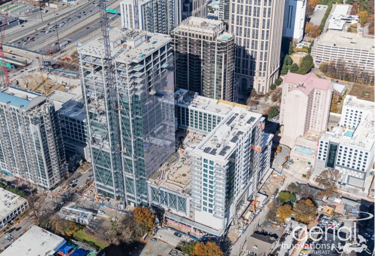 High-angle aerial view of an urban construction site with surrounding buildings.