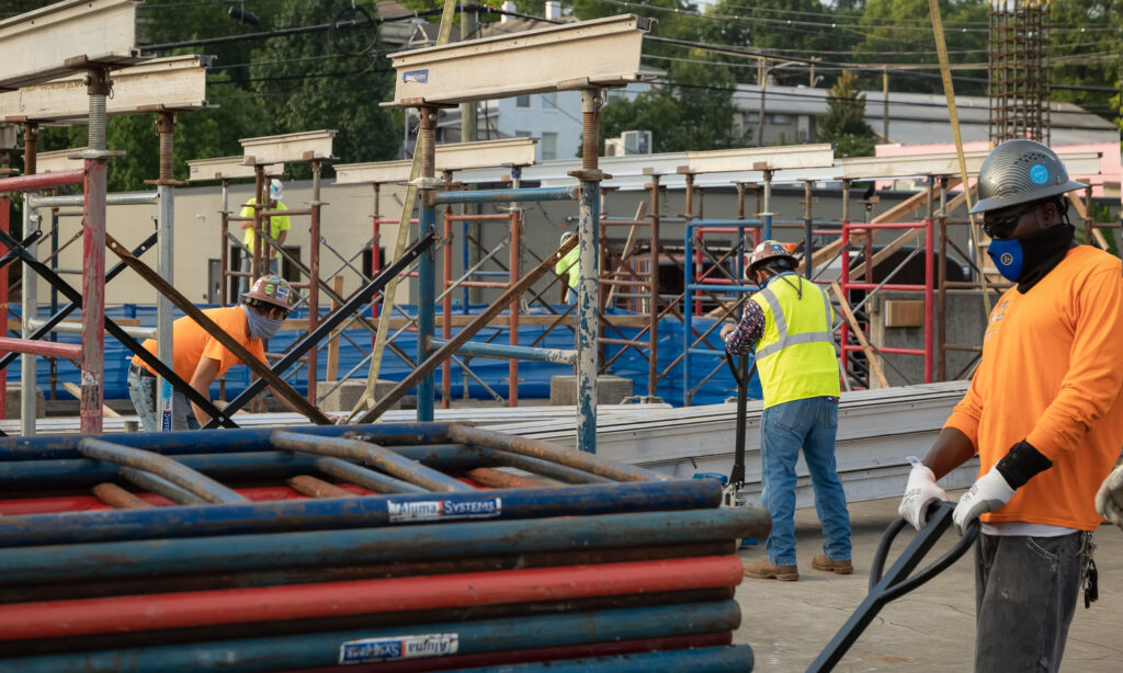 Construction workers in high-visibility clothing operating on a Minority-Owned Construction site.