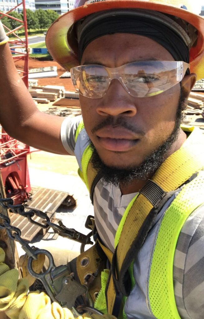 Construction worker in safety gear challenging misconceptions by taking a selfie on site.