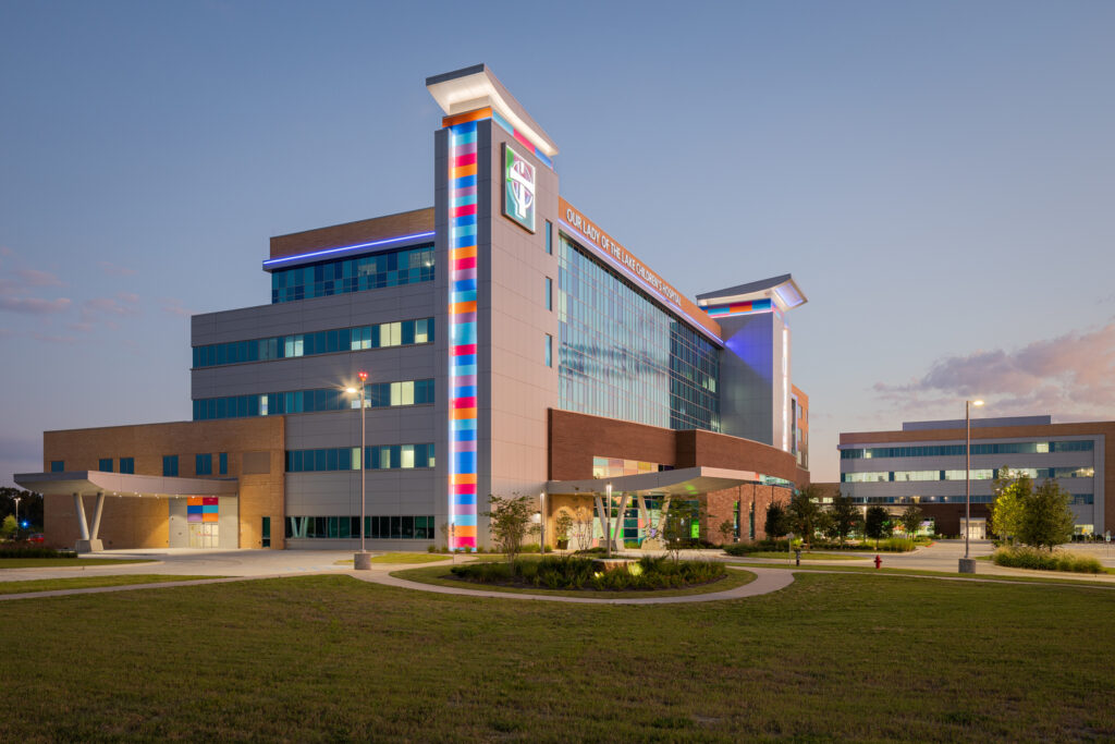 Modern hospital building illuminated at dusk with clear sky, a prestigious project by Brasfield & Gorrie recognized at the National Awards by Associated Builders and Contractors.