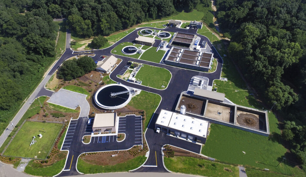 Aerial view of a wastewater treatment plant, awarded National Awards by the Associated Builders and Contractors, featuring various processing tanks and facilities.
