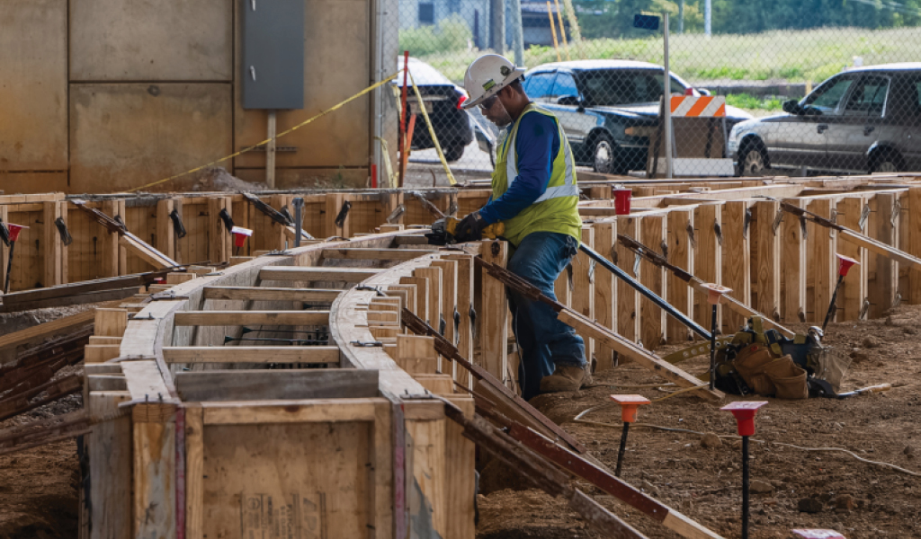 Construction worker installing rebar at a curved concrete formwork site for the Southern Research biotech center.
