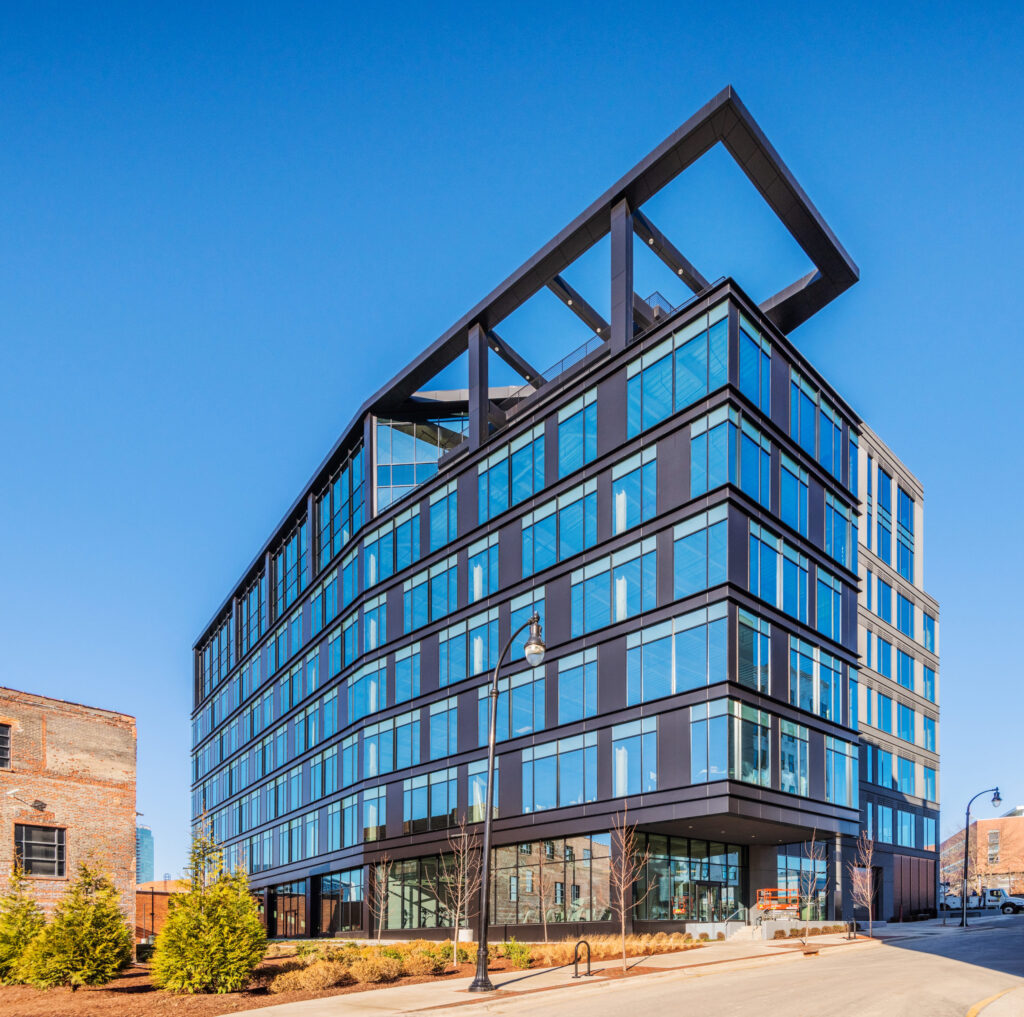 Modern office building, Roxboro at Venable Center, with a distinctive angled roof feature under a clear blue sky completes construction by Brasfield & Gorrie.
