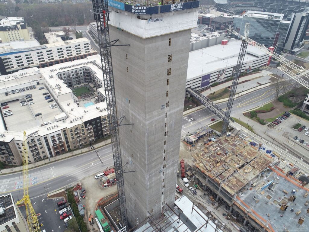 Aerial view of a high-rise building under construction with surrounding infrastructure, exemplifying performance improvement.