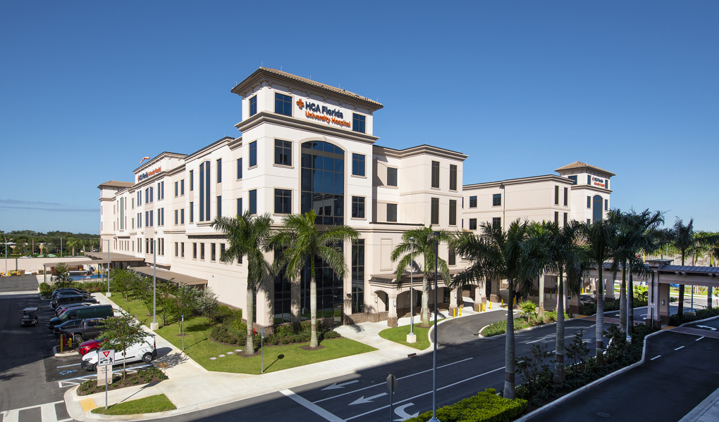 Modern multi-story HCA Florida University Hospital building with parking and landscaped surroundings on a clear day.