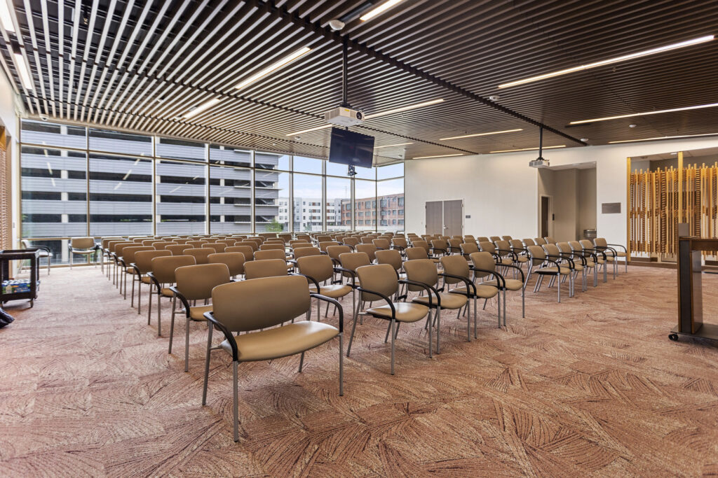 Empty modern conference room with rows of chairs and a projector screen for four projects honored by ENR.