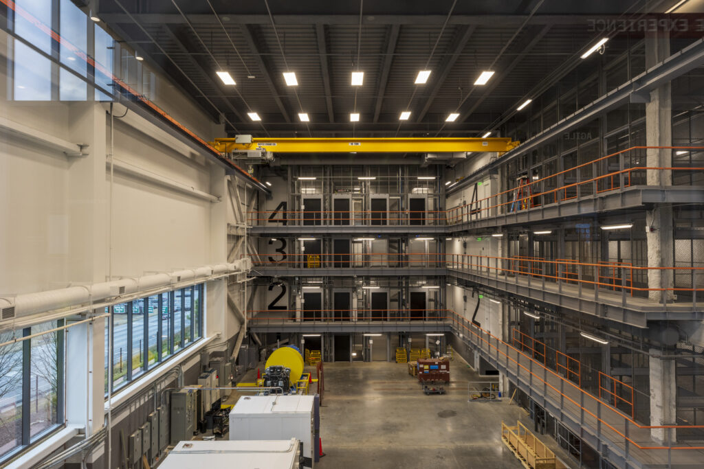 Interior of a multi-level industrial facility with shelving units and machinery, featuring Four Projects honored by ENR.