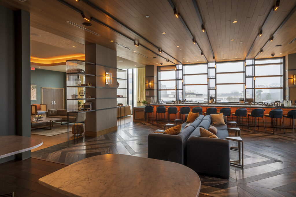 Modern hotel lobby with comfortable seating and an honored bar area.