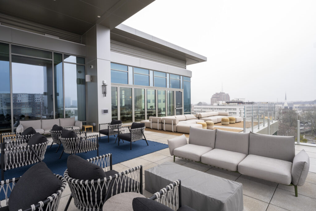 Modern rooftop terrace with comfortable seating, a city skyline view, and recognized as one of the Four Projects Honored.