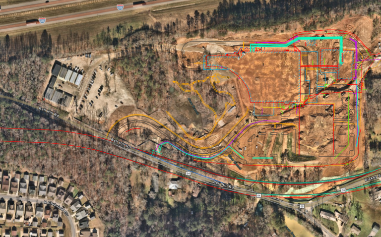 Aerial view of a construction site with marked boundaries, utility mapping, and surrounding infrastructure.