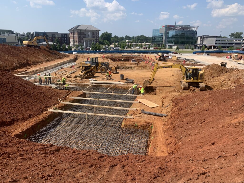Construction site for the Federal Courthouse in Huntsville, Alabama with foundational work in progress and heavy machinery.