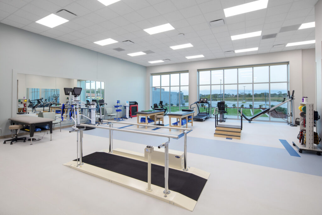 Modern physical therapy clinic located in converted spaces, with various rehabilitation equipment and an exercise area.