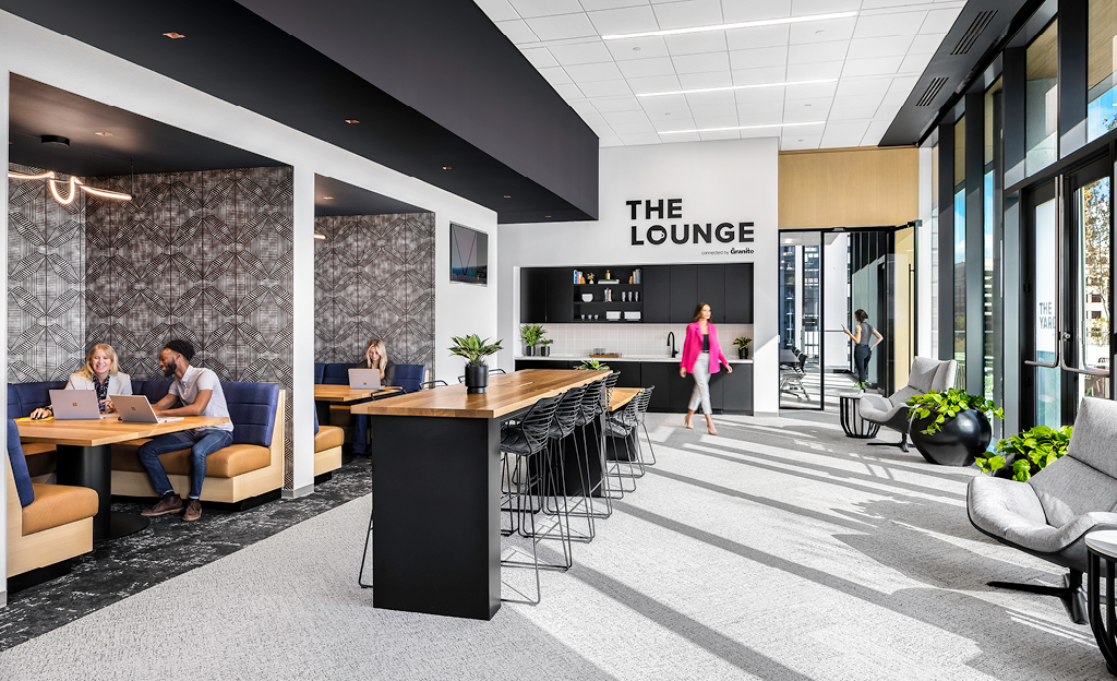 Modern office lounge area in Midtown Union, Atlanta, with individuals working at various seating arrangements.