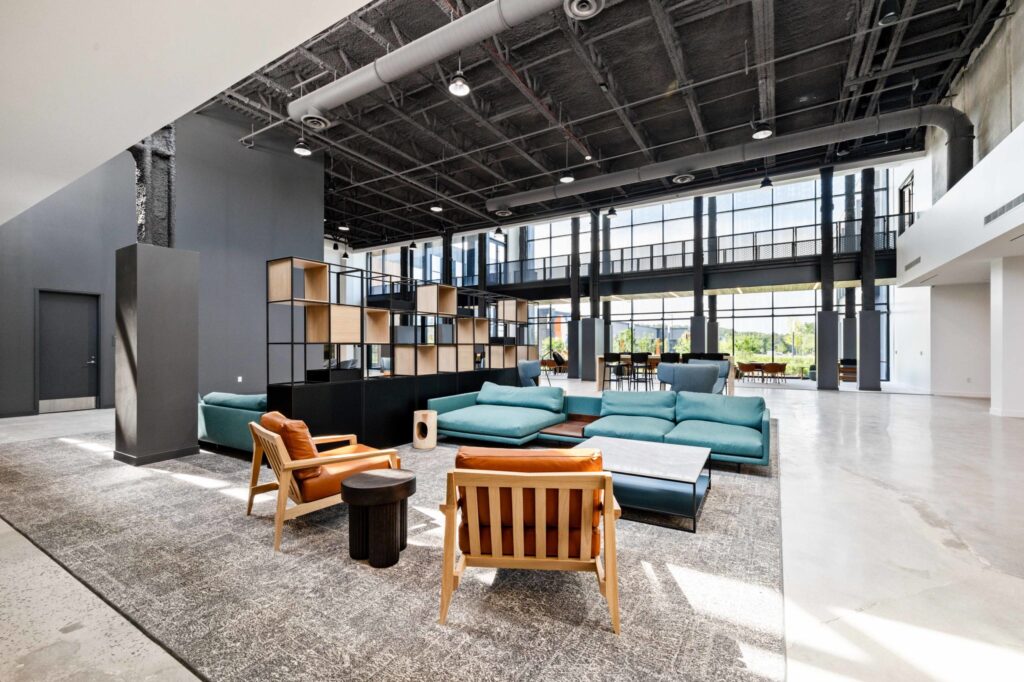Modern office lounge area with contemporary furniture, large windows, and opportunities for developers in converted spaces.