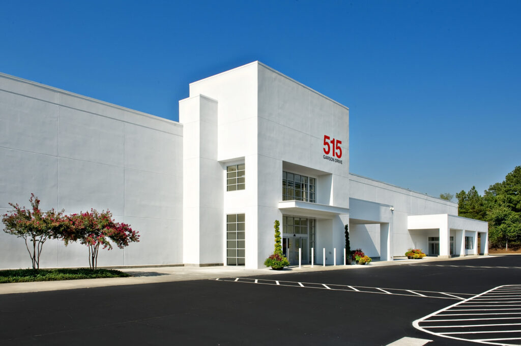 Modern commercial building with a large parking lot on a clear day, offering opportunities for developers and converted spaces.