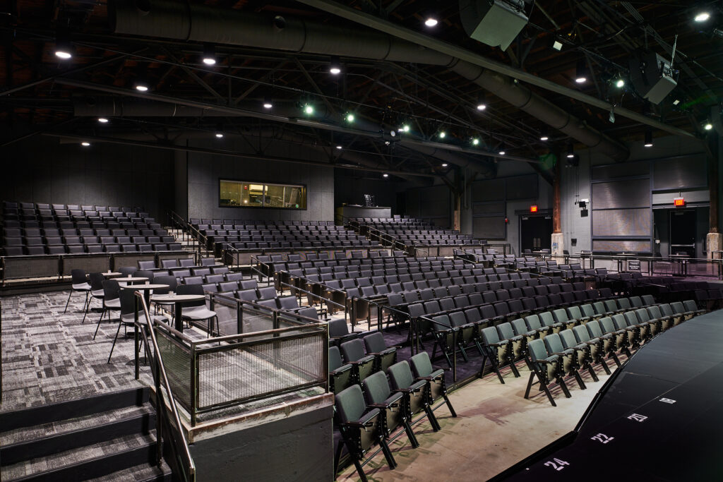 Empty theater auditorium with rows of unoccupied seats and a stage set for a performance, now converted into a space for developers to explore new opportunities.