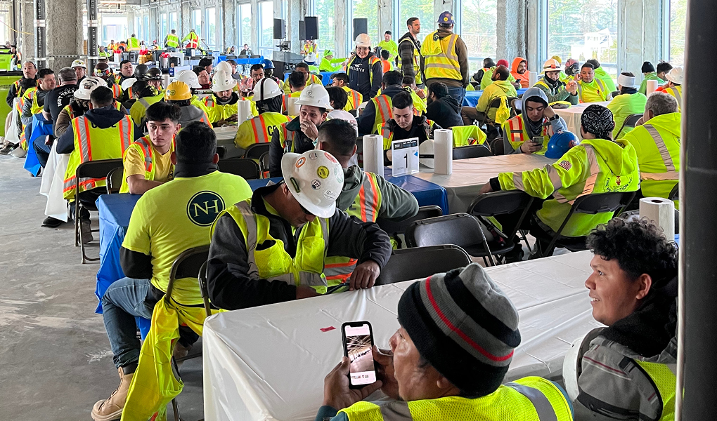 Construction workers in North Hills celebrate a construction milestone by taking a break and socializing in a large communal area.