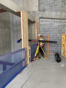 Construction worker using a laser-scanning instrument inside a building under construction at the jobsite.