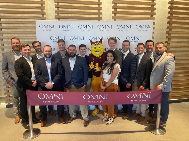 Group of individuals posing for a photo with a mascot at an Omni Tempe Hotel event near ASU.