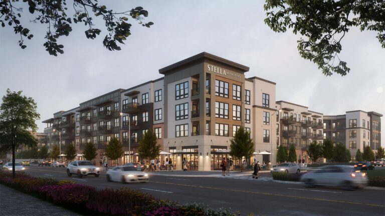 Modern multi-story residential development in North Alabama with ground-floor commercial spaces and bustling street activity at dusk.