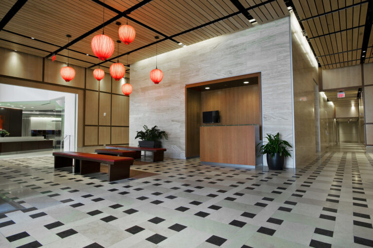 Modern lobby in Greenville, South Carolina with red lanterns, checkered floor, and wood paneling.