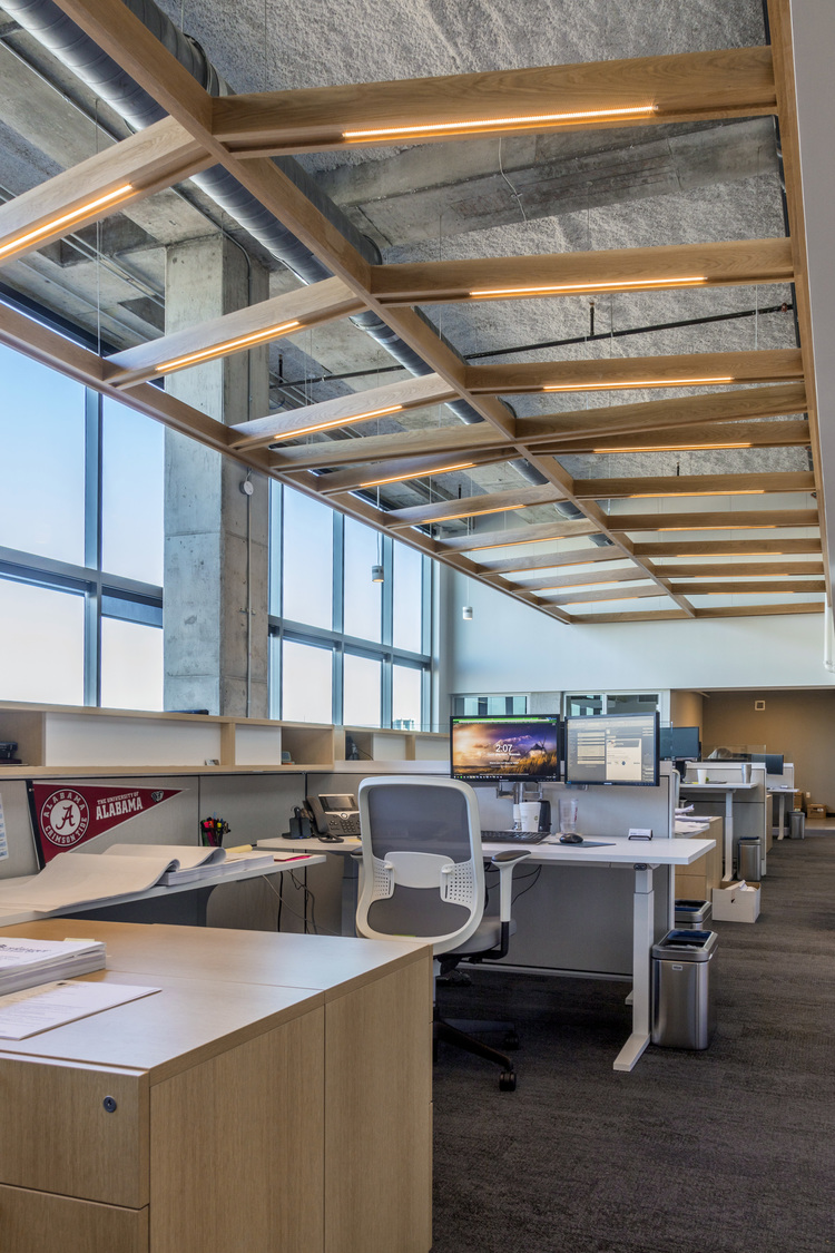 Modern office space in Nashville, Tennessee with natural light, individual workstations, and exposed concrete beams.