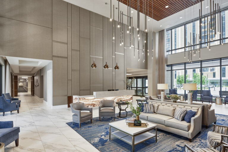 Modern hotel lobby with elegant furnishings and high ceiling, featuring a mix of sofas, chairs, and decorative lighting within the healthcare supersector.