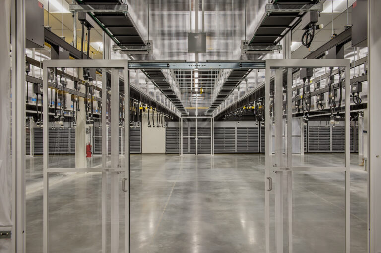 Modern, mission critical data center interior with rows of server equipment racks.
