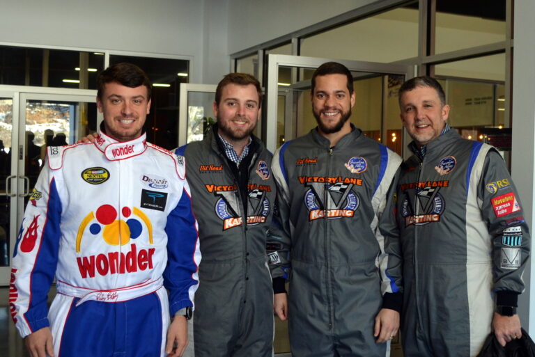 Four men in racing uniforms posing for a photo in Charlotte, NC.