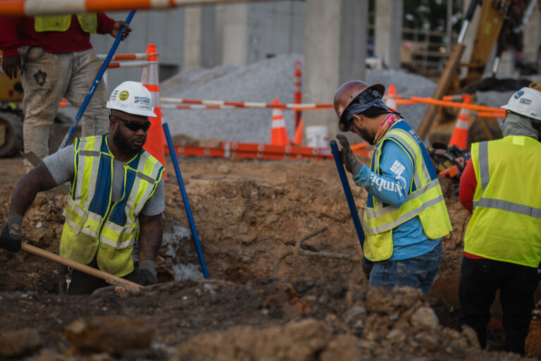 Construction workers engaged in excavation work at a jobsite .