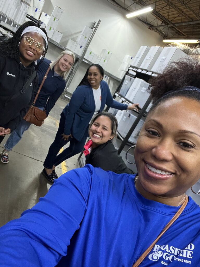 Group of people taking a selfie in a warehouse or storage facility.