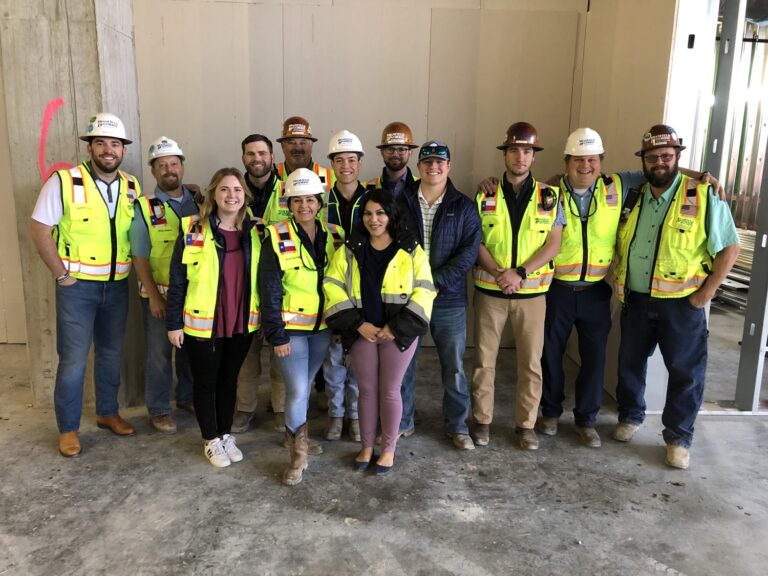 Group of construction workers posing for a photo at a construction site.