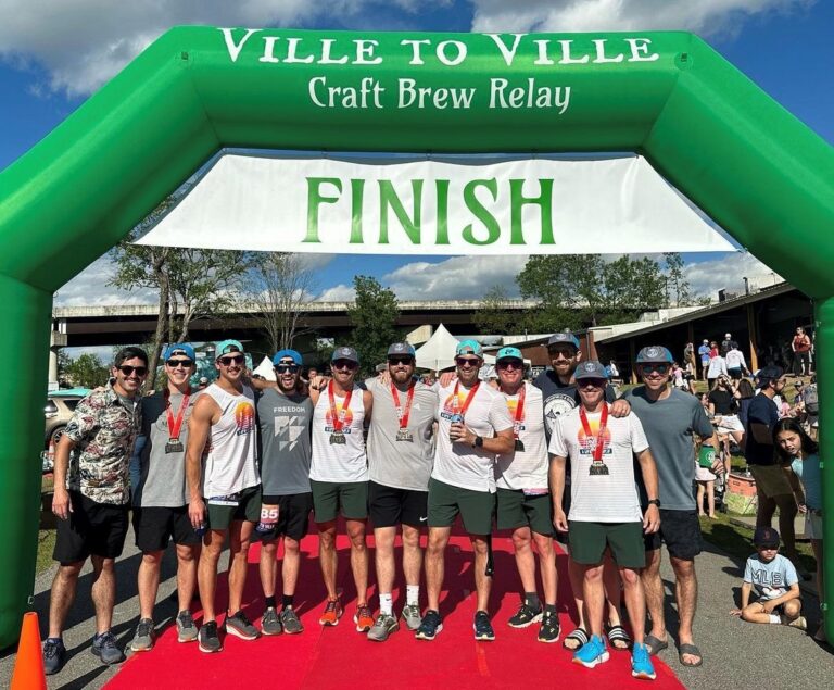 Group of participants posing at the finish line of the ville to ville craft brew relay.