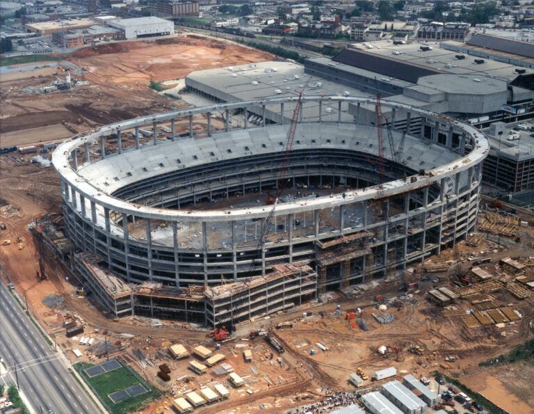 Construction of a grand stadium with multiple levels of seating is in progress.