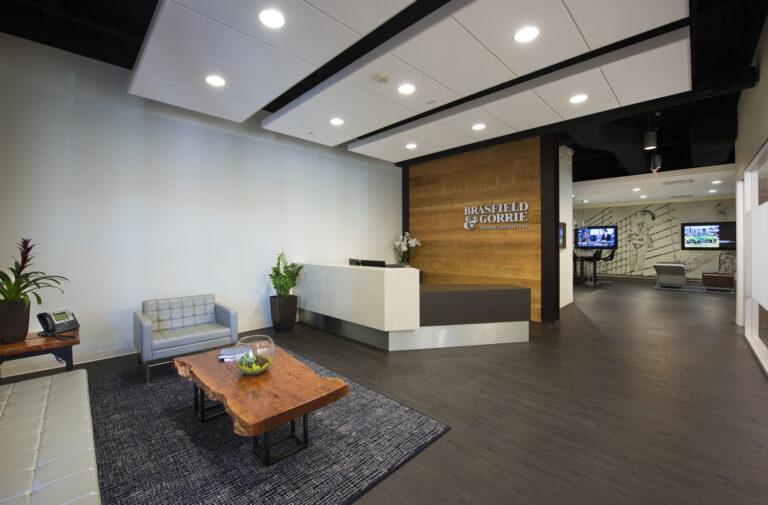 Modern office lobby with reception desk and seating area.
