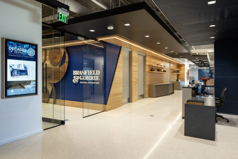 Modern office lobby with a reception desk and company signage.
