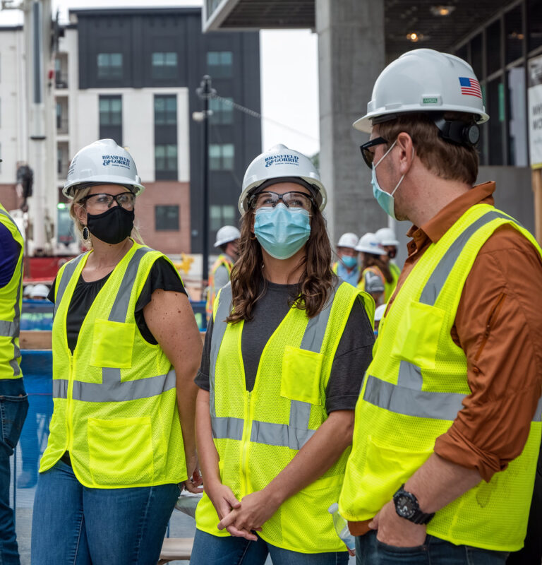 Group of construction workers in safety gear having a discussion at a construction site.