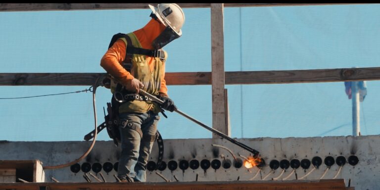 Construction worker using a blowtorch on a job site.