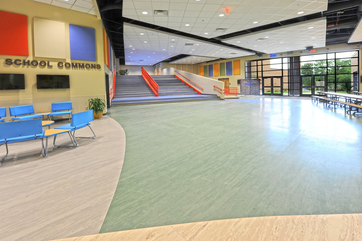 school commons area with acoustical panels on ceiling and large open span area